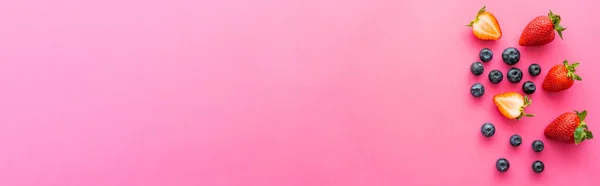 Vista superior de morangos orgânicos e mirtilos em fundo rosa, banner — Fotografia de Stock