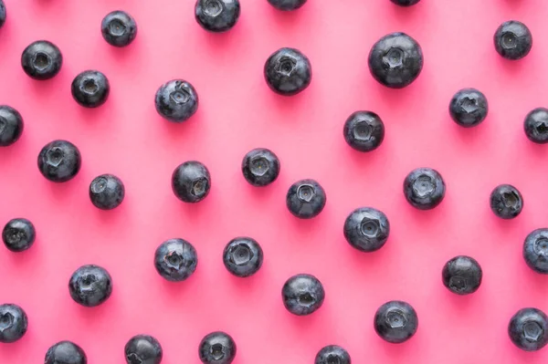 Pose plate avec des bleuets entiers sur fond rose — Photo de stock