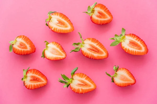 Flache Lage mit geschnittenen Erdbeeren auf rosa Hintergrund — Stockfoto