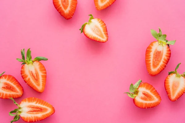 Flat lay with strawberries with green leaves on pink background — Stock Photo