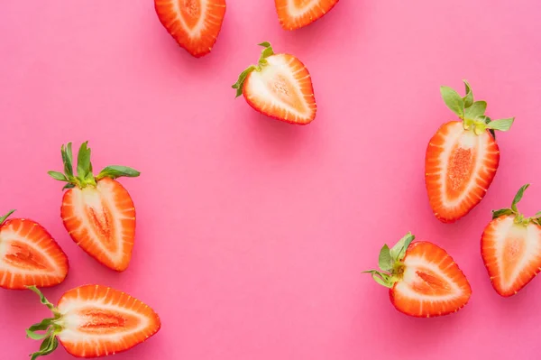 Piatto giaceva con fragole con foglie verdi su sfondo rosa — Foto stock