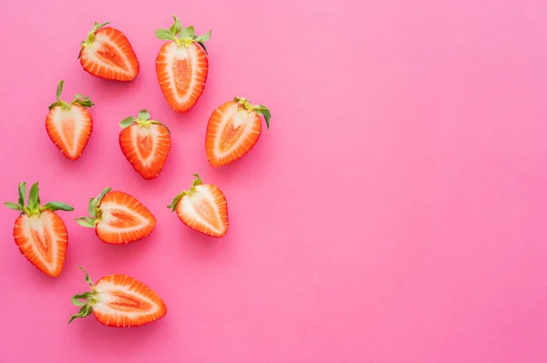 Vue du dessus des fraises coupées sur fond rose avec espace de copie — Photo de stock