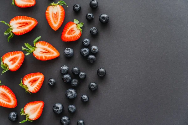 Draufsicht auf natürliche Beeren auf schwarzer Oberfläche — Stockfoto