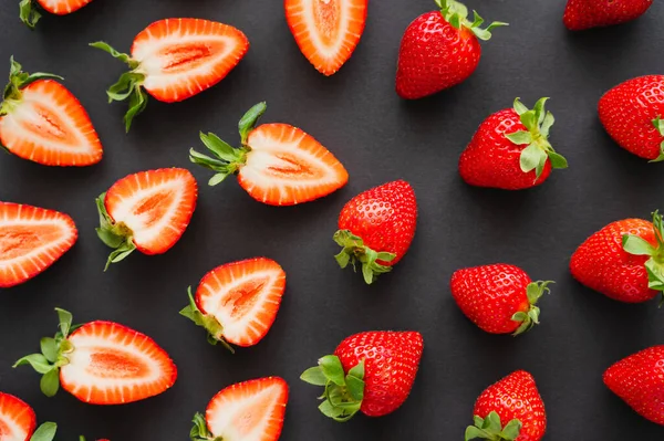 Flache Lage mit natürlichen roten Erdbeeren auf schwarzem Hintergrund — Stockfoto