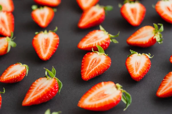 Nahaufnahme von geschnittenen Erdbeeren auf schwarzer Oberfläche — Stockfoto