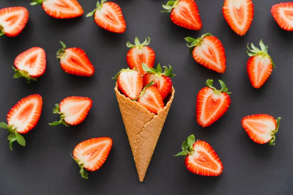 Posa piatta con fragole tagliate in un cono di cialda su fondo nero — Foto stock