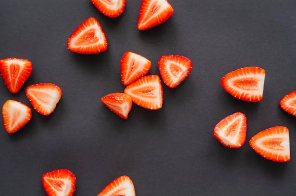Top view of cut strawberries on black background — Stock Photo