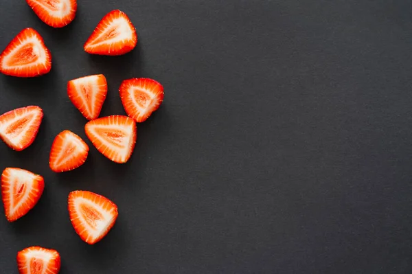 Draufsicht auf saftig geschnittene Beeren auf schwarzem Hintergrund mit Kopierraum — Stockfoto