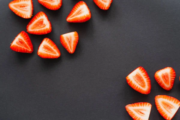 Top view of tasty cut strawberries on black background — Stock Photo