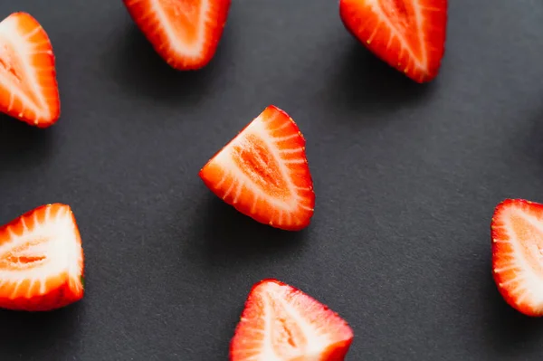 Close up view of cut fresh strawberries on black background — Stock Photo