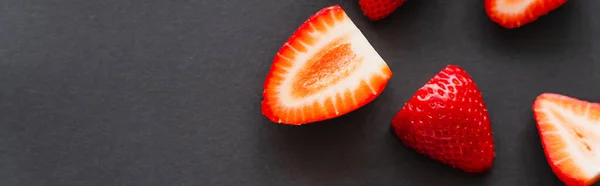 Vista superior de fresas cortadas orgánicas sobre fondo negro, banner - foto de stock