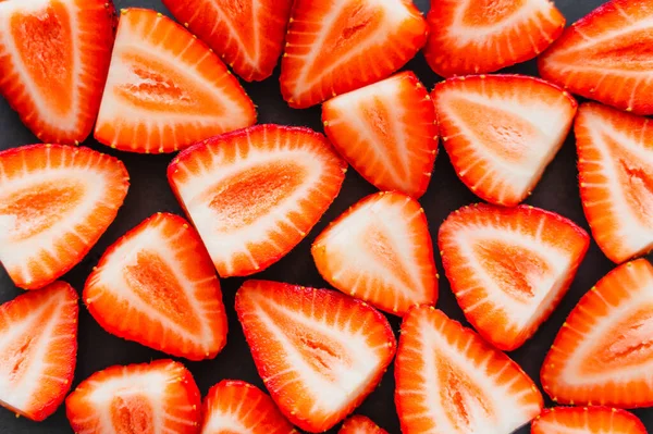 Vue de dessus des fraises fraîches coupées sur fond noir — Photo de stock