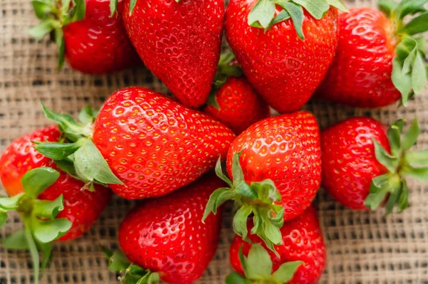 Top view of ripe red strawberries on blurred on sackcloth — Stock Photo