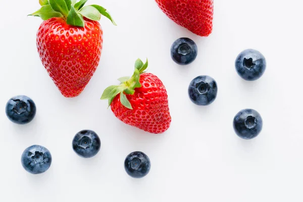 Top view of tasty berries with leaves on white background — Stock Photo
