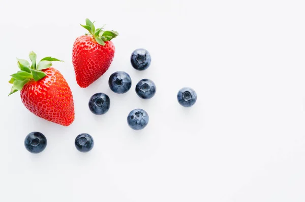 Draufsicht auf frische Blaubeeren und Erdbeeren auf weißem Hintergrund — Stockfoto