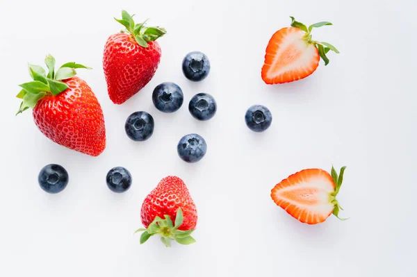 Draufsicht auf ganze und geschnittene Beeren auf weißem Hintergrund — Stockfoto