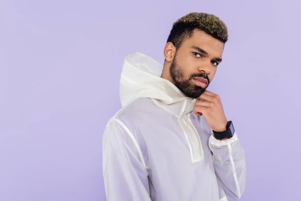 African american sportsman in stylish sportswear looking at camera isolated on purple — Stock Photo