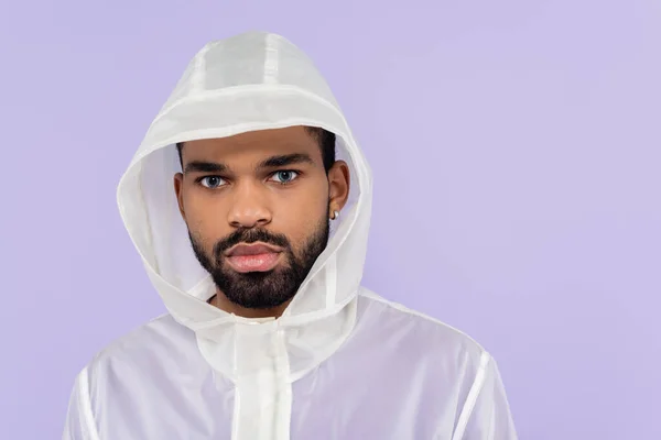 African american sportsman in stylish sportswear with hood looking at camera isolated on purple — Stock Photo