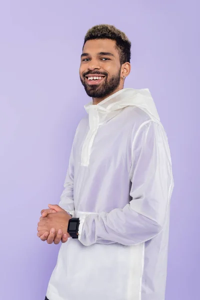 Cheerful young african american sportsman with smart watch posing with clenched hands isolated on purple — Stock Photo