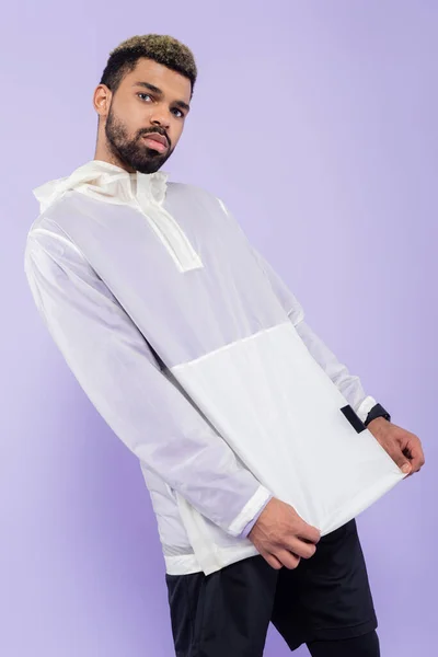 Young african american man in trendy sportswear posing isolated on purple — Stock Photo