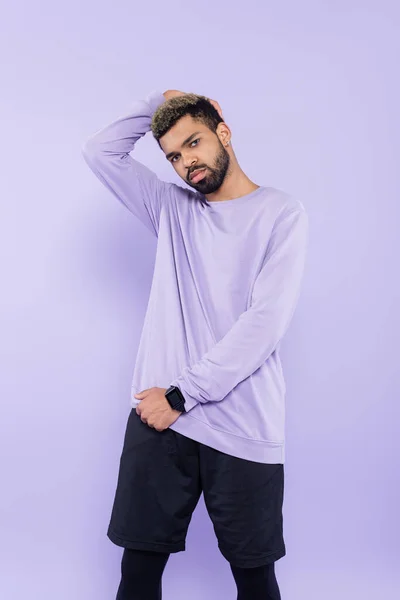 Бородатий афроамериканський чоловік в светрі позує ізольовано на фіолетовому — стокове фото