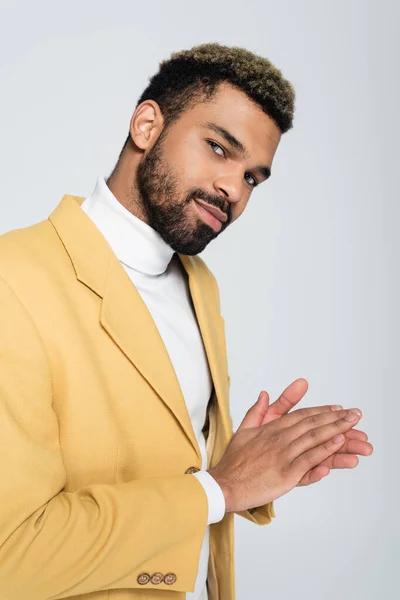 Retrato de hombre afroamericano barbudo con ojos azules en traje elegante aislado en gris - foto de stock