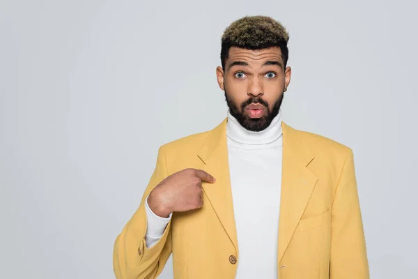 Bearded african american man in turtleneck and yellow stylish blazer pointing at himself isolated on grey — Stock Photo