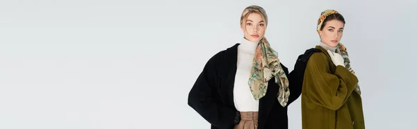 Femme en manteau noir et foulard touchant épaule d'un ami élégant isolé sur gris, bannière — Photo de stock