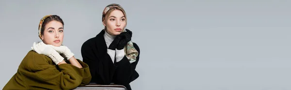 Elegantes mujeres en pañuelos para la cabeza y guantes aislados en gris con espacio para copiar, pancarta — Stock Photo