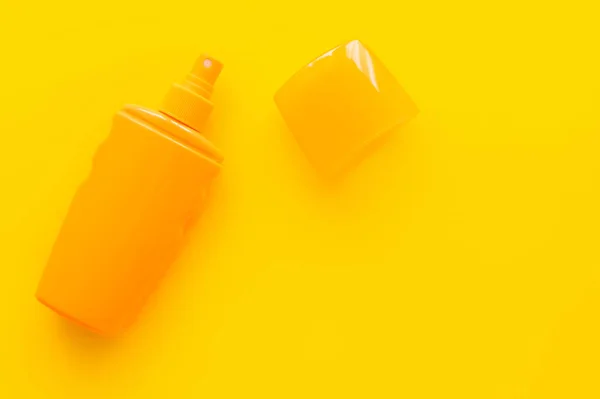 Top view of sunscreen with cup on yellow background — Stock Photo