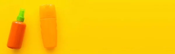 Верхний вид солнцезащитного крема в бутылках на желтом фоне, баннер — стоковое фото