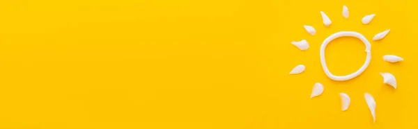 Top view of white sun sign from sunscreen cream on yellow background, banner — Stock Photo