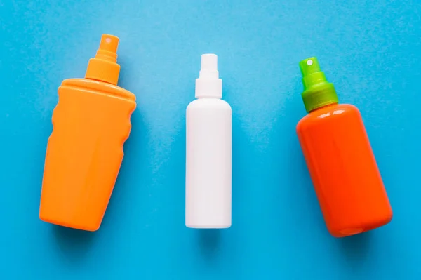 Draufsicht auf Flaschen mit Sonnenschutzmitteln auf blauem Hintergrund — Stockfoto