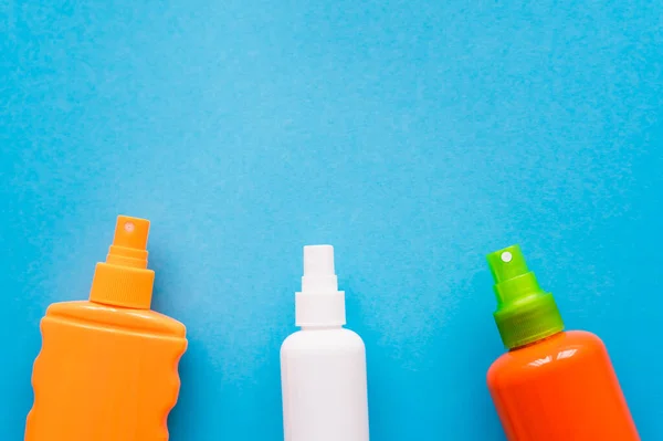 Draufsicht auf Flaschen Sonnencreme auf blauem Hintergrund — Stockfoto