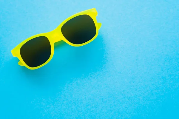 Top view of sunglasses on blue background — Stock Photo