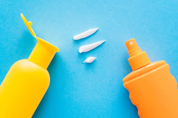 Top view of cream near sunscreens on blue background — Stock Photo