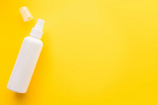 Top view of sunblock with cap on yellow surface — Stock Photo