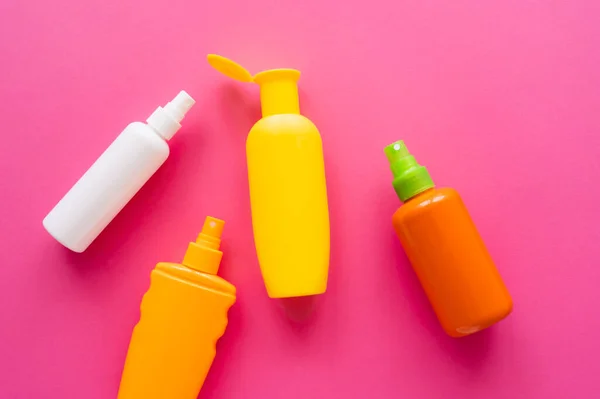 Top view of bottles of sunscreens on pink surface — Stock Photo