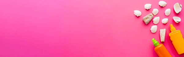 Vista dall'alto di conchiglie e bottiglie di filtri solari su sfondo rosa, banner — Foto stock