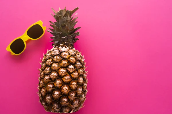 Top view of pineapple and sunglasses on pink background — Stock Photo