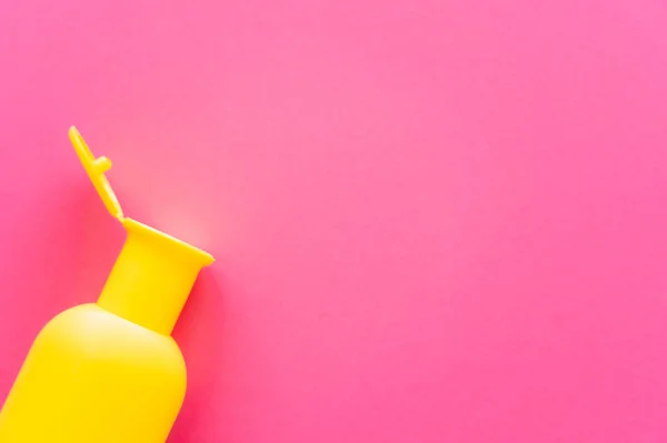 Top view of bottle of sunscreen on pink surface with copy space — Stock Photo