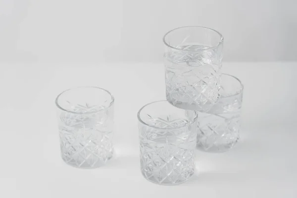 Kristallgläser mit erfrischendem Wasser auf grauem Hintergrund — Stockfoto
