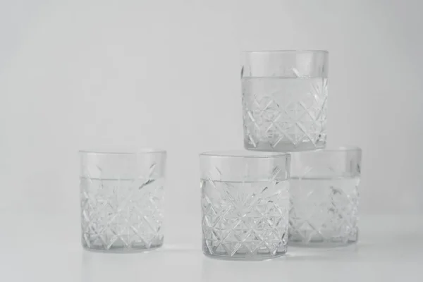 Copos de cristal com água refrescante sobre fundo cinza — Fotografia de Stock
