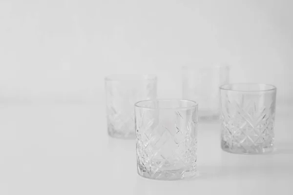 Empty glasses with faceted geometrical pattern on grey background — Stock Photo