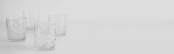 Bicchieri di cristallo vuoti su sfondo grigio con spazio di copia, banner — Foto stock