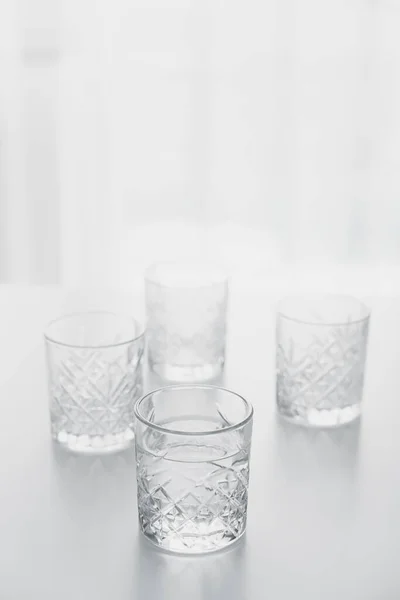 Verre de cristal avec de l'eau propre sur la table sur fond blanc avec espace de copie — Photo de stock