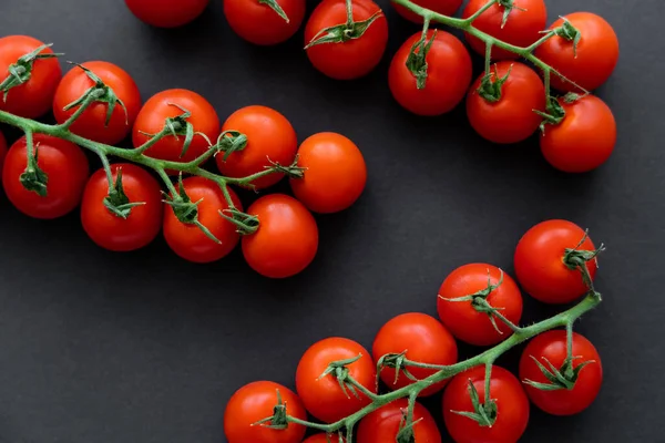 Vue du dessus des tomates cerises sur branches sur fond noir — Photo de stock