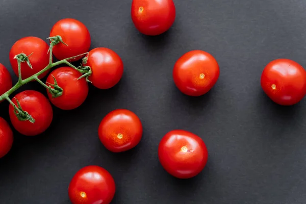 Vista superior de tomates cherry rojos frescos sobre fondo negro - foto de stock