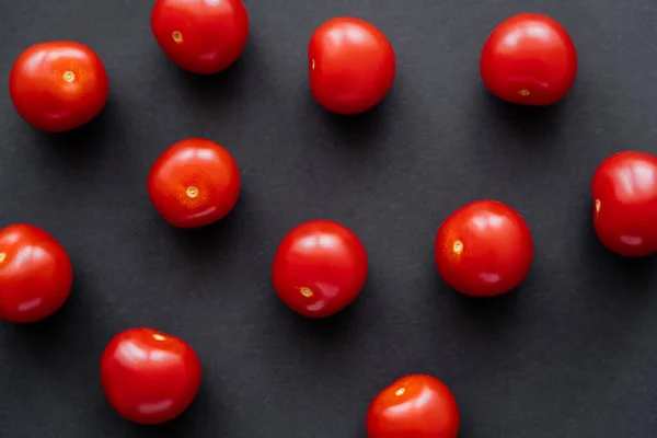 Vista dall'alto di pomodori ciliegia interi naturali su sfondo nero — Foto stock