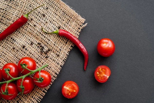 Draufsicht auf natürliches Gemüse und Pfefferkörner auf Sacktuch auf schwarzem Hintergrund — Stockfoto